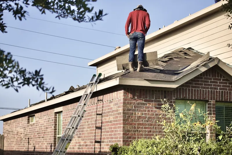Professional roofer working on a residential roof in Highland Park West
